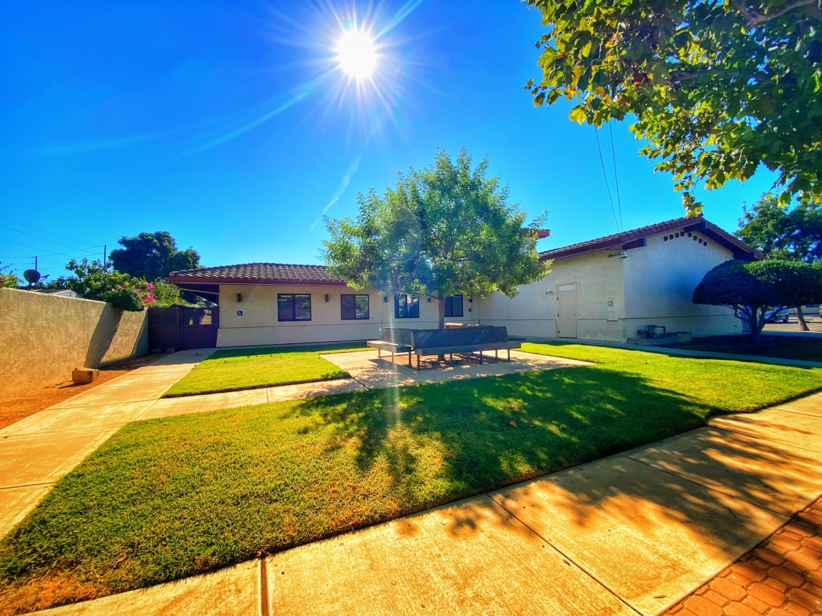 A sunny home with a green lawn under a clear blue sky - Copy